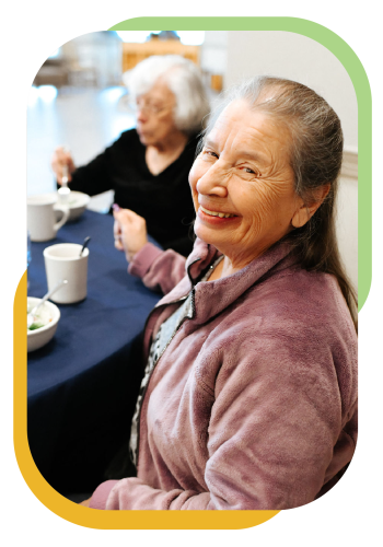 A smiling senior at morning coffee and breakfast at the SRC.